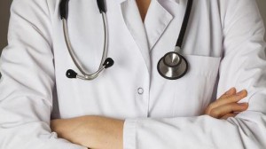 Doctor in white apron standing with stethoscope